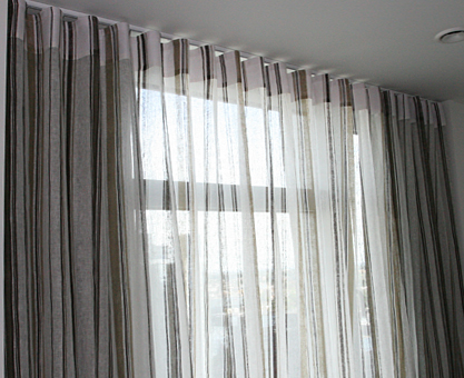 Sheer voile curtains with Ripplefold heading and blackout curtains .