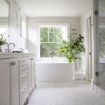Welcoming white bathroom is fitted with honed white marble .