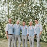 Picture Of groomsmen wearing pink ties and blue vests with grey .