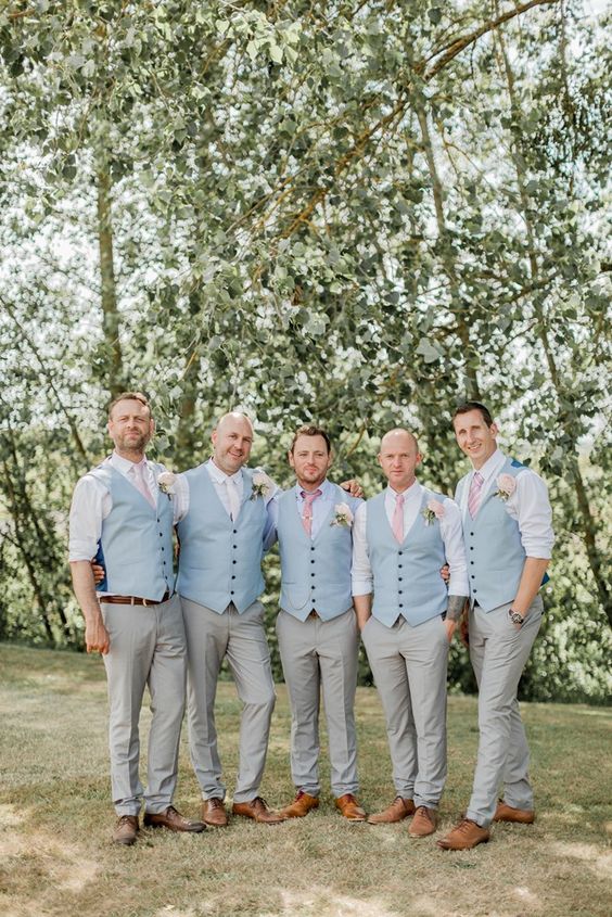 Picture Of groomsmen wearing pink ties and blue vests with grey .