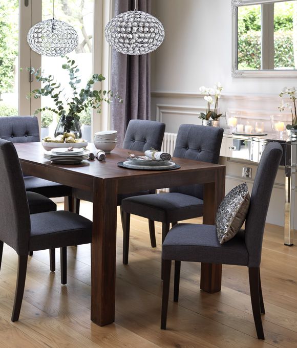 Dining room with dark wood dining table and grey upholstered .