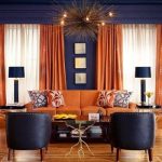 Orange curtains and upholstery against dark grey walls is an .