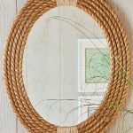 Customize an oval mirror by framing it with coils of rope for a .